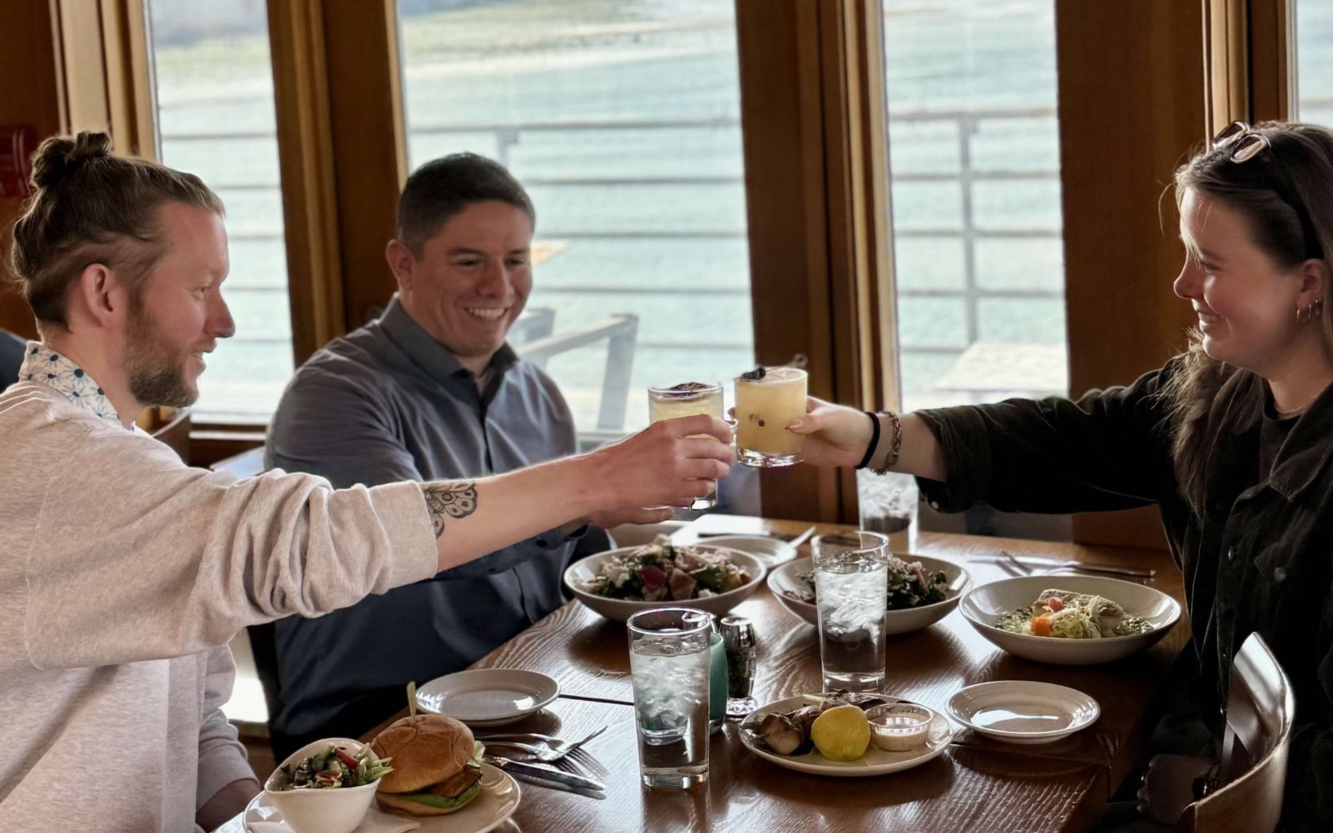 Group of friends cheering their cocktails at Ray's Cafe, Seattle's best casual lunch and dinner restaurant