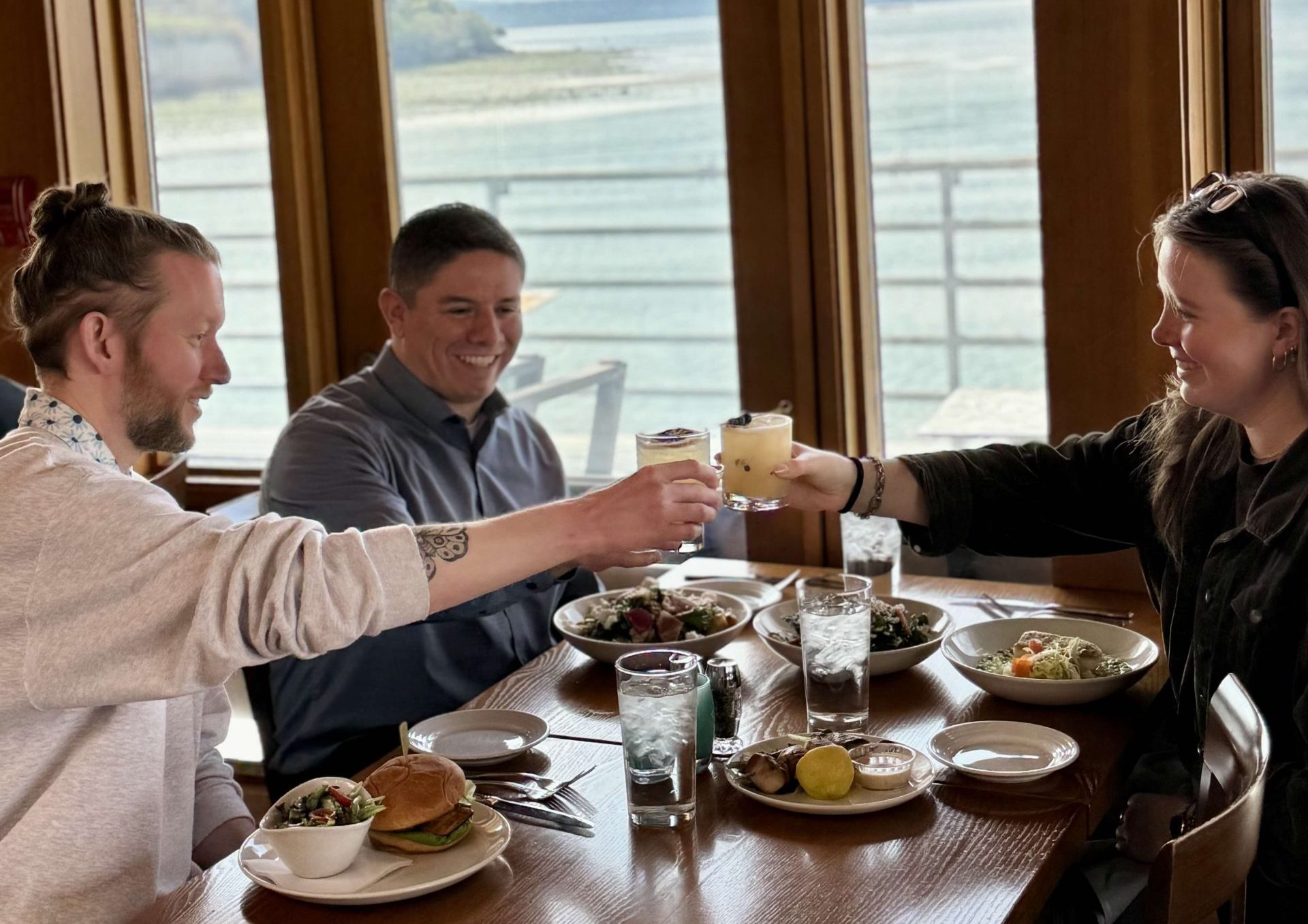Group of friends cheering their cocktails at Ray's Cafe, Seattle's best casual lunch and dinner restaurant