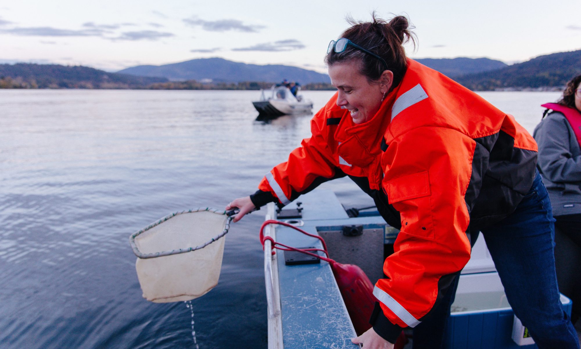 Woman releasing Kokanee salmon into the wild