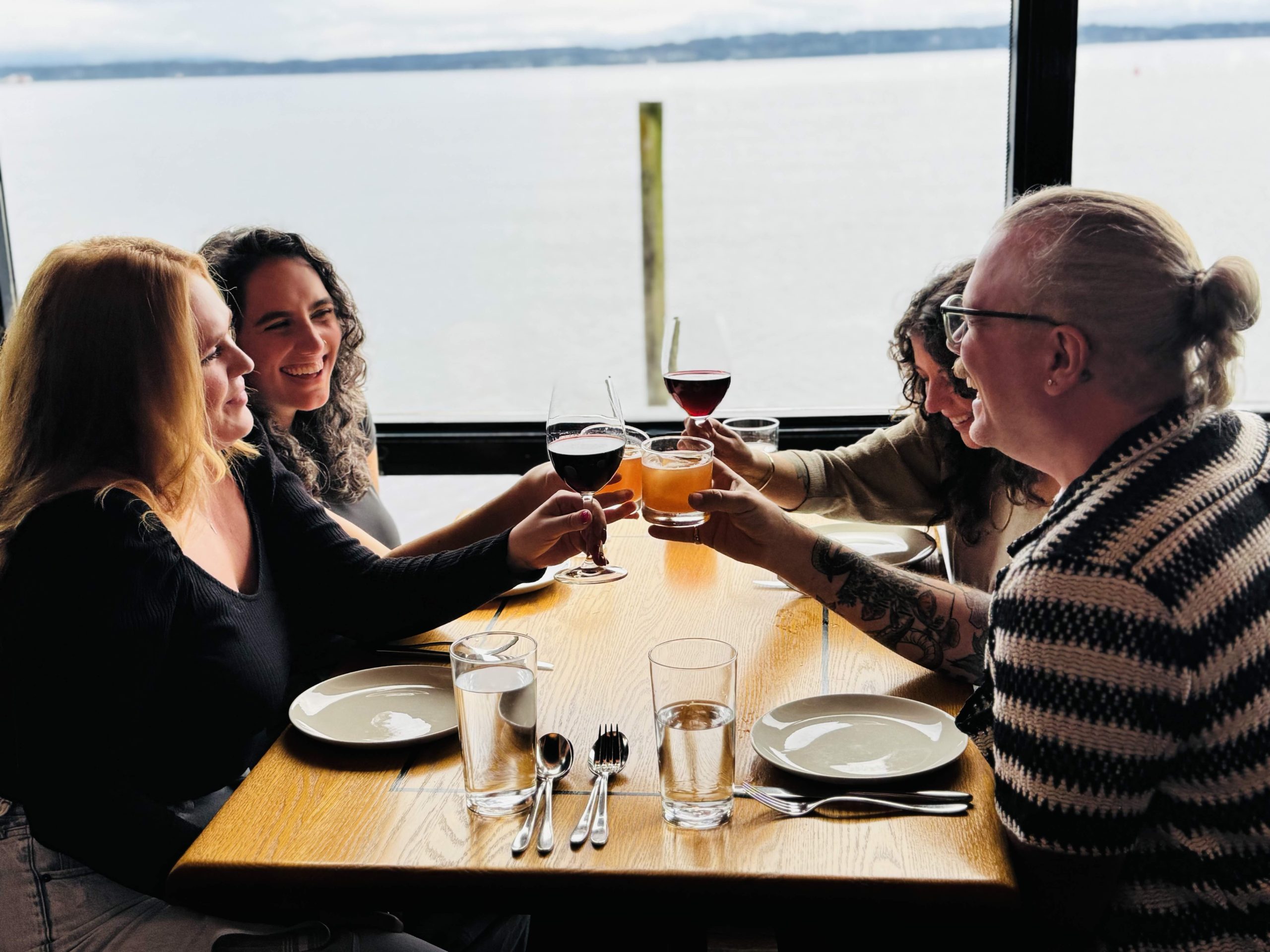 New Year's Eve friends dining at Ray's boathouse with water view and cocktails.