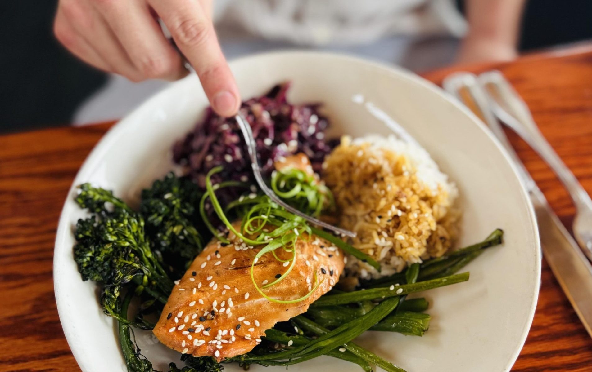 Man eating a salmon teriyaki salmon bowl at Ray's Cafe in Seattle.